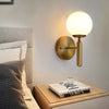 Modern Wall Sconce with Domed Glass Cover in Brass or Black Finish